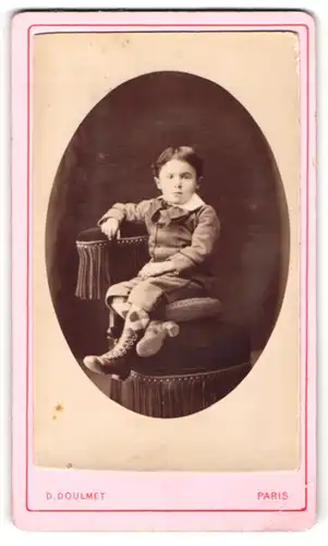 Fotografie D. Doulmet, Paris, Portrait kleiner Junge im Anzug auf Stuhl sitzend