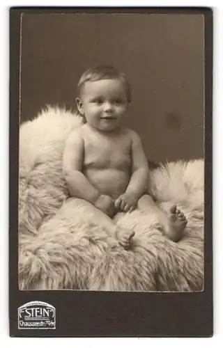 Fotografie Stein, Berlin, Portrait Baby sitzend auf Fell
