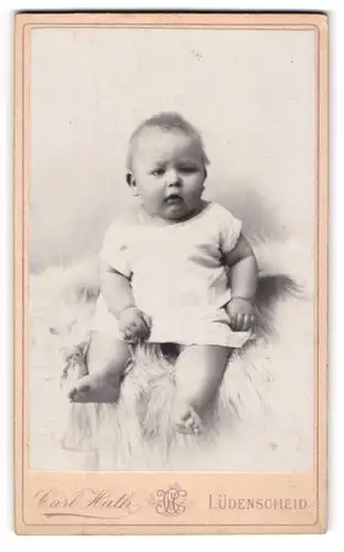 Fotografie Carl Huth, Lüdenscheid, Baby im weissen Hemd auf Fell