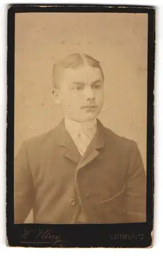 Fotografie H. Klug, Leitmeritz, Portrait junger Herr mit Mittelscheitel in Anzug mit Krawatte