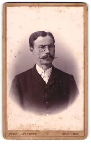 Fotografie Arnold Overbeck, Düsseldorf, Portrait Herr mit imposantem Oberlippenbart und Zwicker