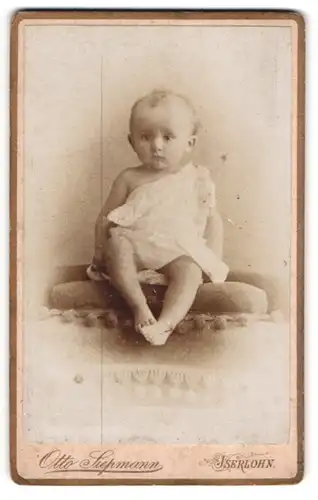 Fotografie Otto Siepmann, Iserlohn, Portrait niedliches Kleinkind im weissen Hemd mit nackigen Füssen