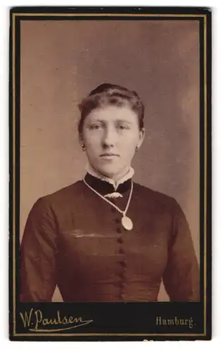 Fotografie W. Paulsen, Hamburg, Portrait junge Dame im schwarzen Kleid mit Amulett