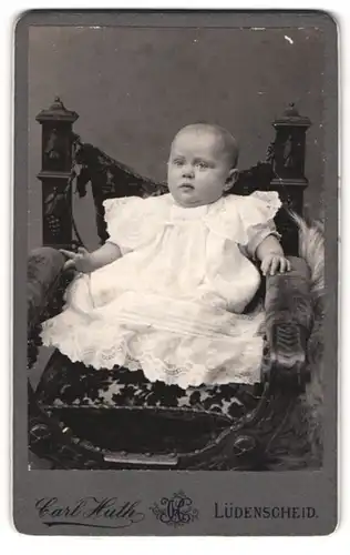 Fotografie Carl Huth, Lüdenscheid, Portrait niedliches Kleinkind im weissen Kleid auf Stuhl sitzend