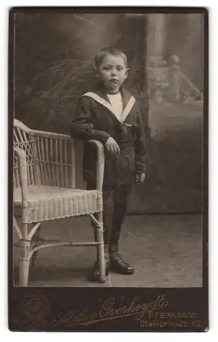 Fotografie Atelier Overheydt, Sterkrade, Portrait kleiner Junge im Matrosenanzug an Stuhl gelehnt