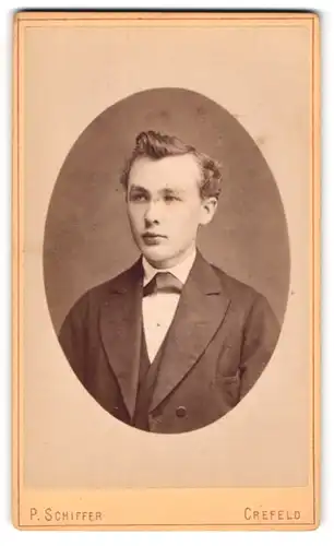Fotografie P. Schiffer, Crefeld, Portrait charmanter junger Mann mit Fliege im Jackett