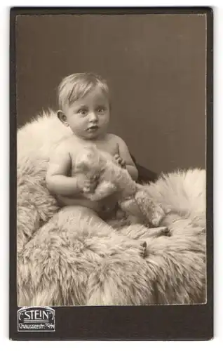 Fotografie Atelier Stein, Berlin, Portrait süsses blondes Kleinkind mit Kuscheltier in den Händen