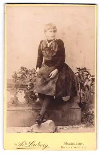 Fotografie A. Ludwig, Magdeburg, Portrait blondes Mädchen im Kleid auf einem Geländer sitzend
