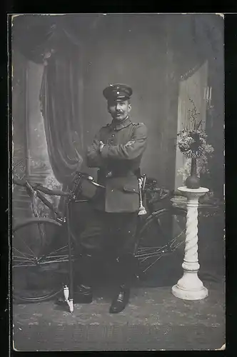 Foto-AK Soldat in Uniform Rgt. XI 3 mit seinem Dienstrad / Fahrrad und Pfeife, 1915