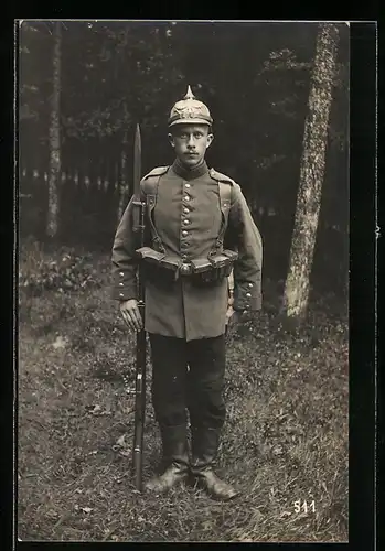 Foto-AK preussischer Soldat Philipp Ankermann in Uniform mit Ersatzpickelhaube und Ausmarschgepäck, Bajonett auf Gewehr