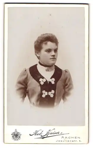 Fotografie Hubert Kaiser, Aachen, Portrait hübsche junge Frau mit Brosche und Stickerei am Kleid