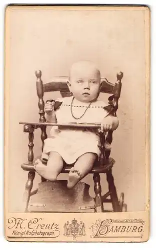 Fotografie M. Creutz, Hamburg, Portrait Säugling in Kindersitz