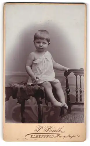 Fotografie P. Barth, Elberfeld, Portrait niedliches Kleinkind im weissen Hemd auf Tisch sitzend