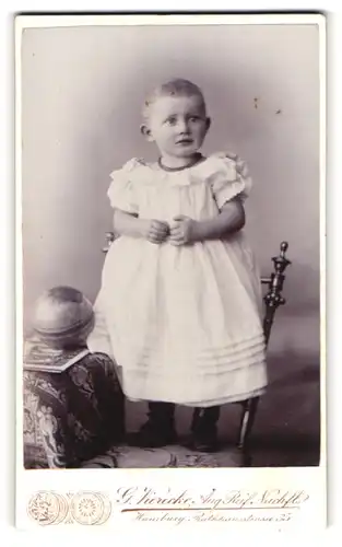 Fotografie G. Vierecke, Hamburg, Portrait kleines Mädchen im weissen Kleid auf Stuhl stehend