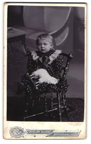 Fotografie P. Gliese, Reichenau i / S., Portrait niedliches Kleinkind im gepunkteten Kleid mit Spieltier