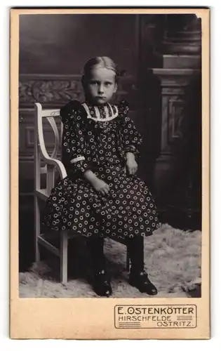 Fotografie E. Ostenkötter, Ostritz, Mädchen in Sonntagskleidung schmollend auf einem Stuhl