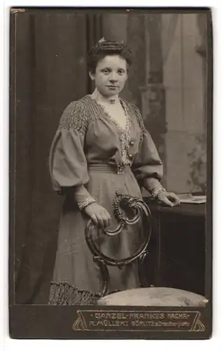 Fotografie Ganzel-Frankes Nachf., Görlitz, Portrait junge Dame im hübschen Kleid an Stuhl gelehnt