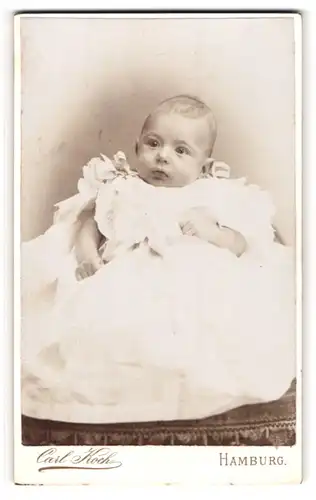 Fotografie Carl Koch, Hamburg, Portrait niedliches Baby im weissen Kleid mit Schleifchen