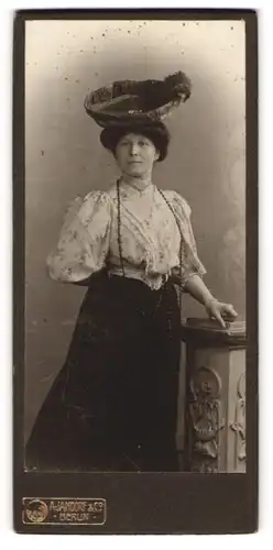 Fotografie A. Jandorf, Berlin, Portrait Frau in weisser Bluse und schwarzem Rock, einen ausgefallen Hut tragend