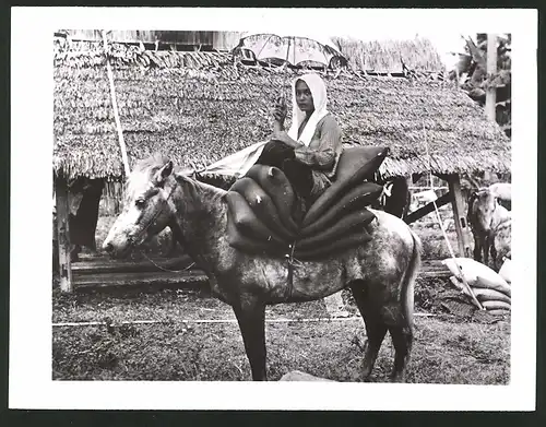 Fotografie Fischerin aus Makassar zu Pferd