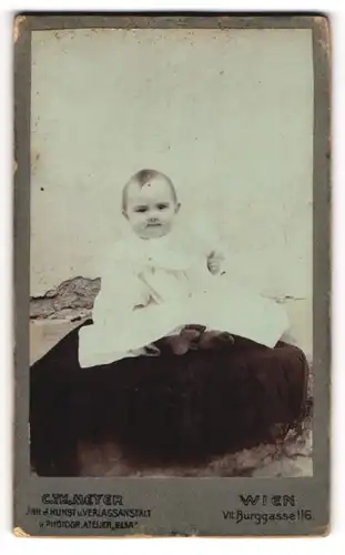 Fotografie Carl Th. Meyer, Wien, Portrait niedliches Kleinkind im weissen Kleid mit nackigen Füssen