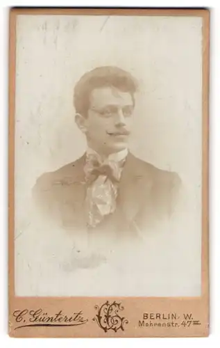 Fotografie C. Günteritz, Berlin-W, Portrait junger Mann im Anzug mit Fliege und Schnurrbart