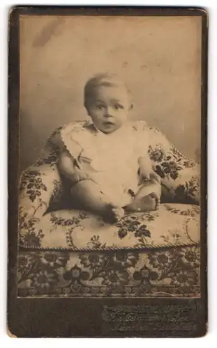 Fotografie F. X. Ostermayr`s Söhne, München, Portrait niedliches Kleinkind im weissen Hemd auf Sessel sitzend