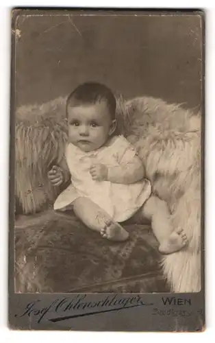 Fotografie Josef Ohlenschlager, Wien, Portrait niedliches Kleinkind im weissen Hemd mit nackigen Füssen