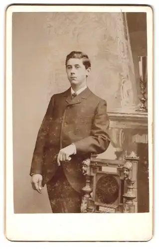 Fotografie unbekannter Fotograf und Ort, Portrait junger Mann im Anzug an Stuhl gelehnt