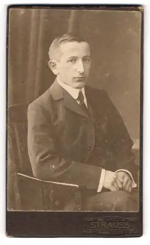 Fotografie Atelier Strauss, Leipzig, Portrait modisch gekleideter Herr auf Stuhl sitzend