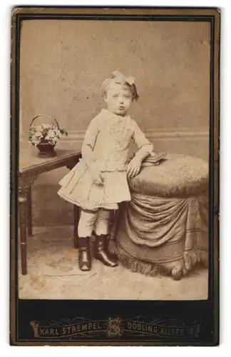 Fotografie Karl Strempel, Döbling, Portrait hübsch gekleidetes Mädchen mit Büchern an Hocker gelehnt