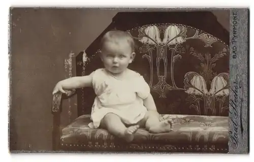 Fotografie Paul Stecher, Bad Pyrmont, Portrait niedliches Kleinkind im weissen Hemd auf Bank sitzend