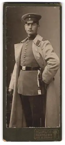 Fotografie A. Hellmuth, Aschersleben, Portrait Soldat im Uniformmantel mit Schirmmütze