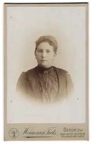 Fotografie Hermann Tietz, Berlin, Portrait hübsche Dame mit Brosche am Kleiderkragen