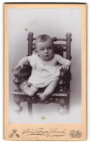 Fotografie Rob. Trefzger, Lörrach, Portrait süsses Kleinkind im weissen Hemdchen auf Stuhl sitzend