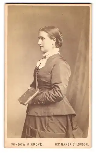 Fotografie Window & Crove, London, Portrait hübsch gekleidete junge Frau mit Buch in der Hand