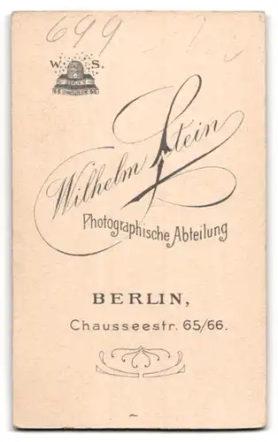 Fotografie Wilhelm Stein, Berlin, Portrait niedliches Kleinkind im karierten Kleid auf Fell sitzend