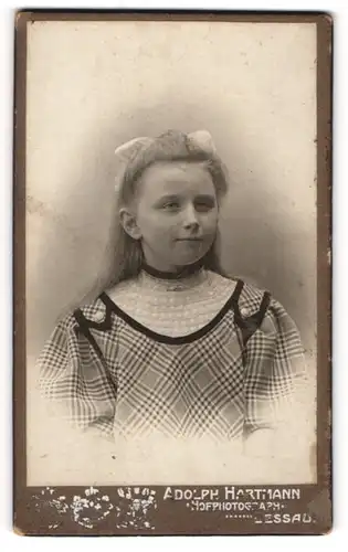 Fotografie Ad. Hartmann, Dessau, Portrait junges Mädchen im karierten Kleid mit Haarschleife