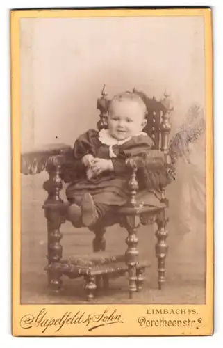 Fotografie Stapelfeld & Sohn, Limbach i / S., Portrait niedliches Kleinkind im hübschen Kleid auf Stuhl sitzend