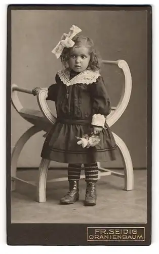 Fotografie Fr. Seidig, Oranienbaum, Portrait kleines Mädchen im hübschen Kleid mit Blumen