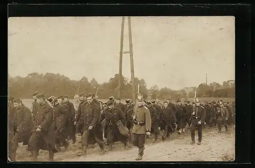 AK Marschierender Zug von Kriegsgefangenen auf einer Strasse