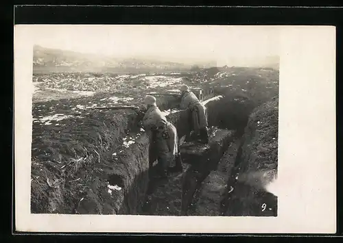 Foto-AK deutsche Soldaten mit Stahlhelm im Schützengraben beim Wachdienst, Wintermäntel
