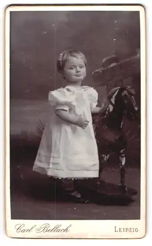 Fotografie Carl Bellach, Leipzig, niedliches kleines Mädchen mit ihrem Holzpferd auf Rollen