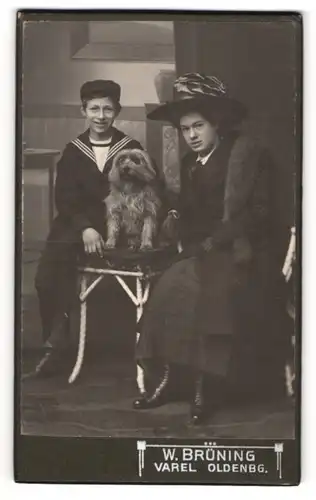 Fotografie W. Brüning, Varel, Mutter und Sohn Wallheimer mit ihrem Hund auf dem Tisch im Atelier