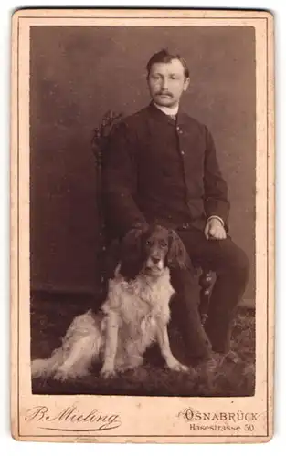 Fotografie B. Mieling, Osnabrück, Herr im Anzug mit seinem Hund im Atelier