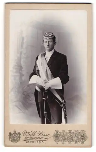 Fotografie Wilh. Risse, Marburg a. L., junger Student im Anzug mit Schläger und Biertönnchen, Couleur