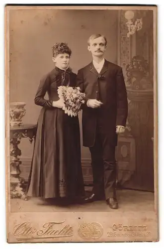Fotografie Otto Facht, Görlitz, sächsisches Ehepaar im schwarzen Brautkleid und im Anzug, Brautstrauss