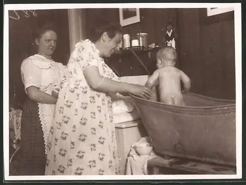 Fotografie Baby wird im Waschzuber gebadet
