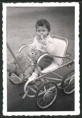 Fotografie Kleinkind mit Teddybär im Kinderwagen sitzend