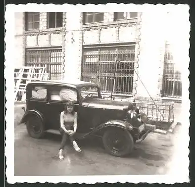 Fotografie Auto, junge Frau auf PKW-Trittbrett sitzend